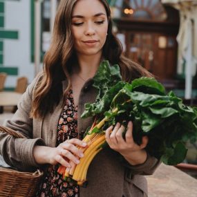 Young woman with a basket shopping for fresh vegetables outdoors in Erfurt, Germany.